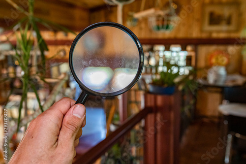 Indoor damp & air quality (IAQ) testing. A closeup view on the hand of a building inspector using a magnification lens to search for signs of damp, rot, mold & mildew inside a residential house. photo