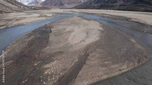 Tilt up Forward Motion Revealing Glacier Runoff and Beautiful Mountains in the Background.  photo