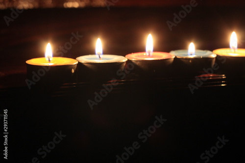 Colorful candles lined on the wooden fence. It's a romantic moment to memorial to some one who passed away with love.