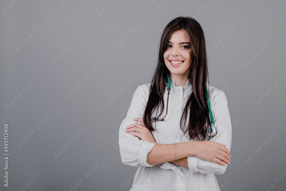 beautiful young smiling doctor in medical robe isolated over grey beautiful young smiling doctor in medical robe isolated over grey