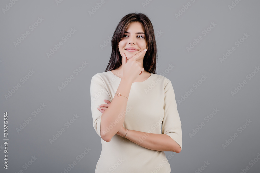 beautiful brunette woman smiling and thinking isolated over grey beautiful brunette woman smiling and thinking isolated over grey