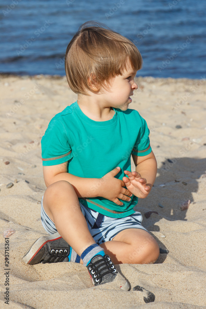 Baby boy on summer beach. Vacation time and child development concept Baby boy on summer beach. Vacation time and child development concept