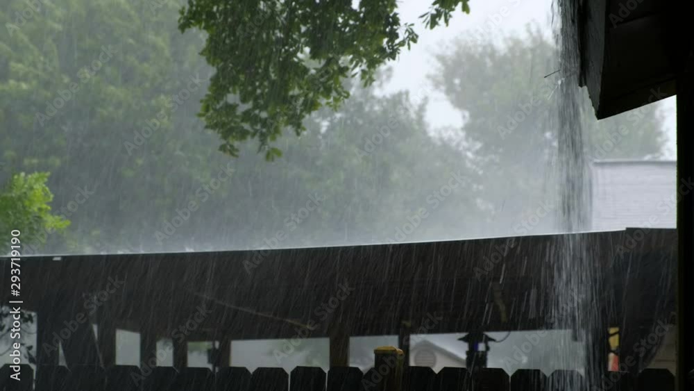 Heavy rain coming off a house roof during autumn heavy rain. Pouring over covered patio