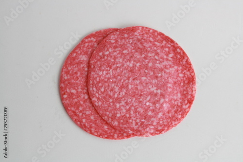 slices of salami on white background