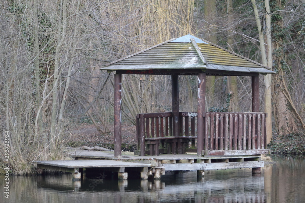 An old wooden gazebo with jetty built close to a lake shore