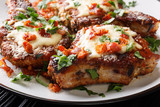 Baked pork chops with cheese and bacon closeup on a plate. horizontal