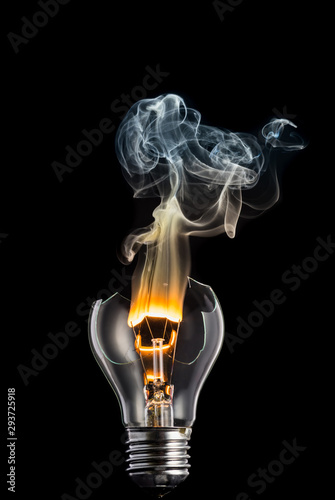 broken light bulb and smoke from a burning spiral on a black background