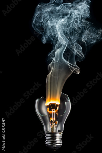 broken light bulb and smoke from a burning spiral on a black background
