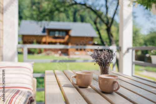 Summer, morning. On the veranda are two cups of coffee and a vase of lavender. Good morning