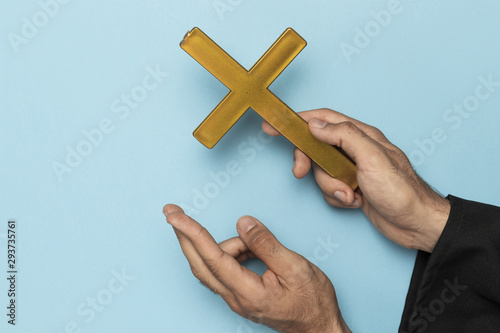 Priest with cross finger and wood cross