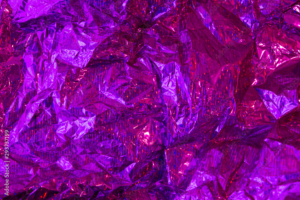 Obraz premium Creative purple photo background of crumpled foil with highlights and shadows.