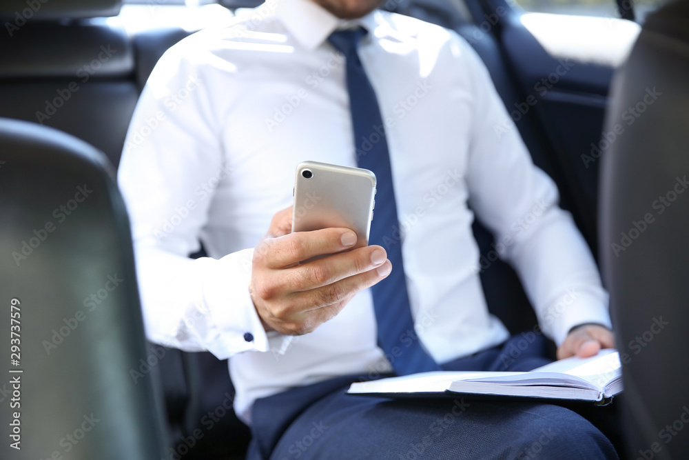 Successful businessman with mobile phone in modern car Successful businessman with mobile phone in modern car