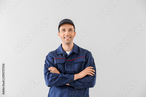 Male car mechanic on light background