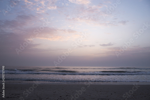 Dawn on the Mediterranean coast  Tunisia Sand in the foreground  small waves  the sun above the horizon