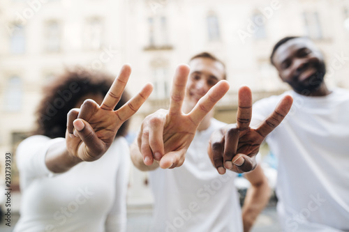 Intercultural friends showing peace sign