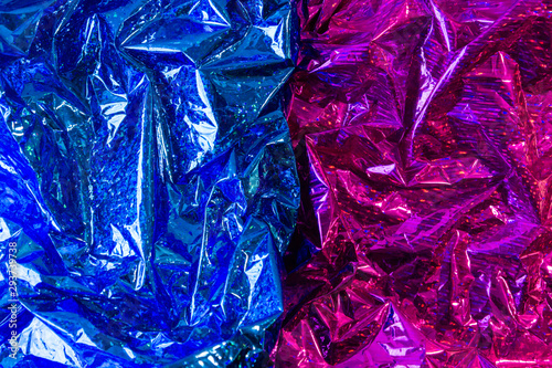 Creative photo background of blue and purple crumpled foil with highlights and shadows