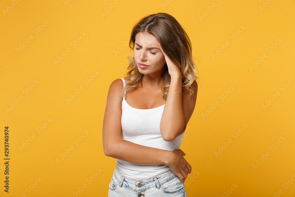 Exhausted young woman girl in light casual clothes posing isolated on yellow orange background. People lifestyle concept. Mock up copy space. Keeping eyes closed putting hand on head, having headache.
