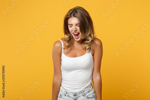 Crazy young woman in light casual clothes posing isolated on yellow orange background, studio portrait. People sincere emotions lifestyle concept. Mock up copy space. Screaming, keeping eyes closed.