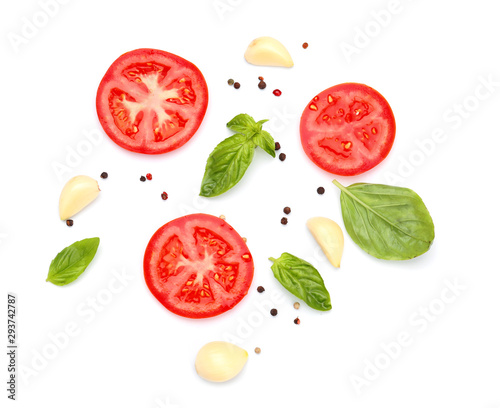 Fototapeta Naklejka Na Ścianę i Meble -  Pieces of fresh tomato and spices on white background