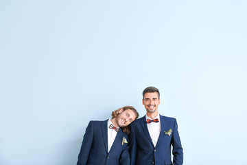 Portrait of happy gay couple on their wedding day against color background