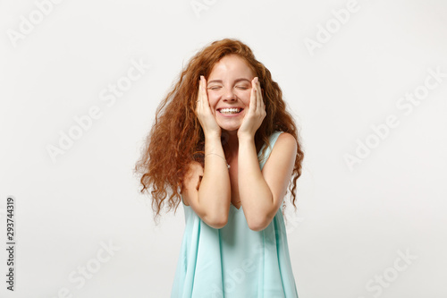 Young smiling redhead woman in casual light clothes posing isolated on white background. People sincere emotions lifestyle concept. Mock up copy space. Keeping eyes closed, putting hands on cheeks.