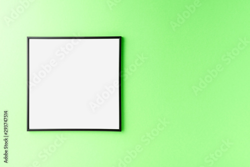 Black photo frame with copyspace on green background. Home decoration