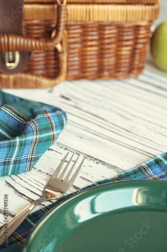 Close up of a wooden basket with dishware on white table