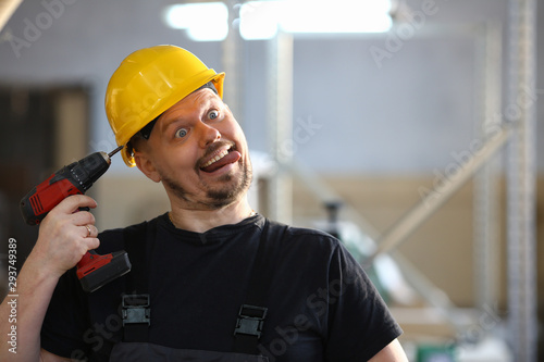 Idiot worker using electric drill portrait. Manual job DIY inspiration improvement fix shop yellow helmet joinery startup idea industrial education profession career concept