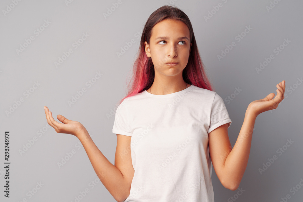 Image of thinking teen girl standing over a gray background Image of thinking teen girl standing over a gray background