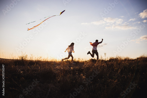 Young couple have fun with kite. they send Genuine emotions  to the world.