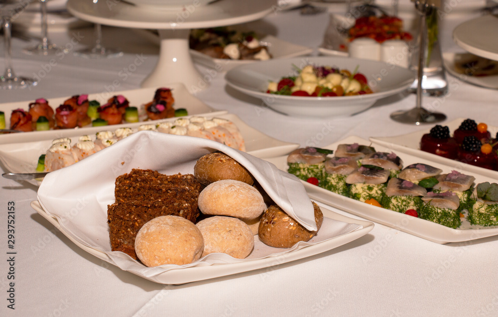 Bread rolls on a gala table in a restaurant under a white napkin Bread rolls on a gala table in a restaurant under a white napkin