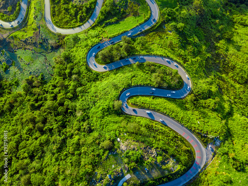 Aerial view of winding road through valley of the mountain. Top view from drone.