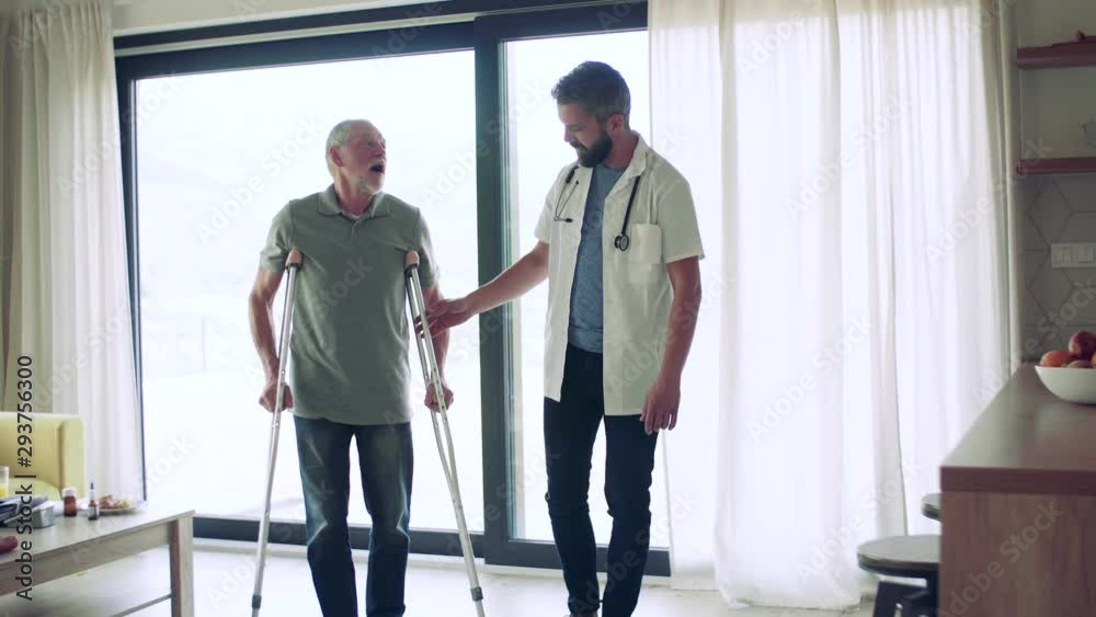 Health visitor and a senior man with crutches during home visit, walking. Health visitor and a senior man with crutches during home visit, walking.