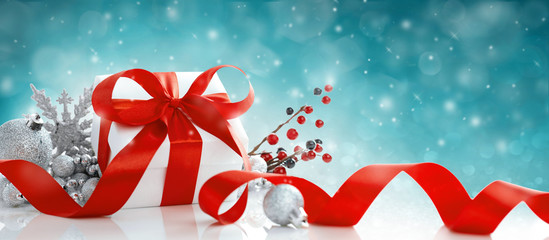 Red Christmas gift box and baubles on blue background