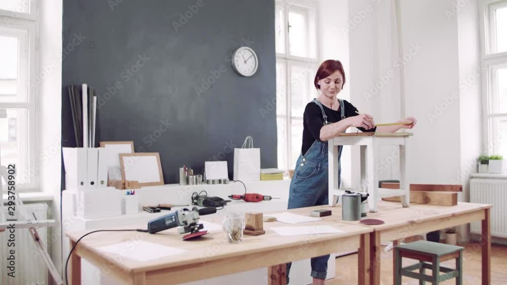 Young woman indoors restoring old furniture. Young woman indoors restoring old furniture.