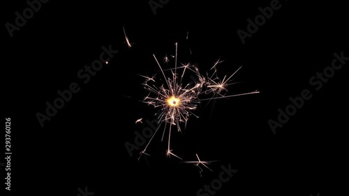 Christmas sparklers burning in the dark. Firework sparkler burning with lights in background. Christmas or new year party glowing burning sparklers. Holiday festival concept. Festive fire. photo