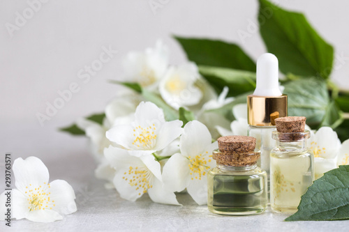 Essential jasmine oil. Massage oil with jasmine flowers on a wooden background