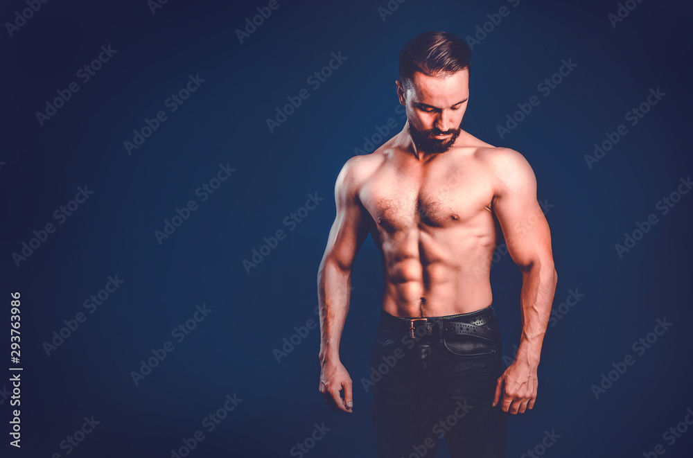 Fototapeta premium Moderately pumped male fitness model with embossed muscles, copy space