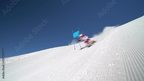 4K sport footage, professional ski racer with start number one skiing super g on sunny winter day with clear blue sky