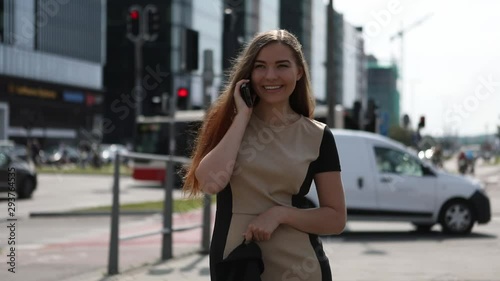 Young woman talking on the phone in busy city center photo