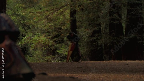 Wounded medieval knight confronted by warrior in the woods photo