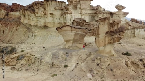 Man walking behind rock formations at bolnuevo murcia photo