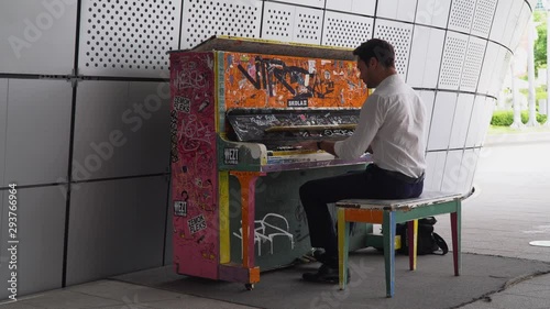 Man plays on colorful piano at Dongdaemun design plaza in seoul. Tripod shot. photo