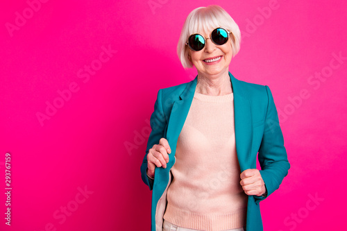 Portrait of her she nice-looking attractive cheerful cheery gray-haired lady wearing blue green jacket enjoying life lifestyle isolated on bright vivid shine vibrant pink fuchsia color background