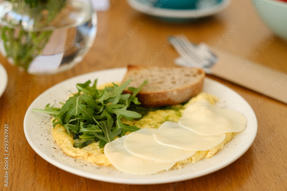 omelet with arugula cheese and a slice of bread omelet with arugula cheese and a slice of bread