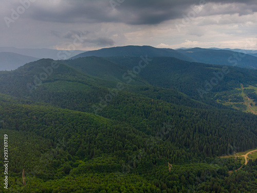 Aerial view over mountain road going through forest landscape. Transylvania, Romania