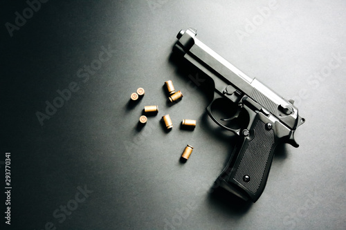 Gun with bullets lying on the table. Legalising of weapons. Criminal problems. photo