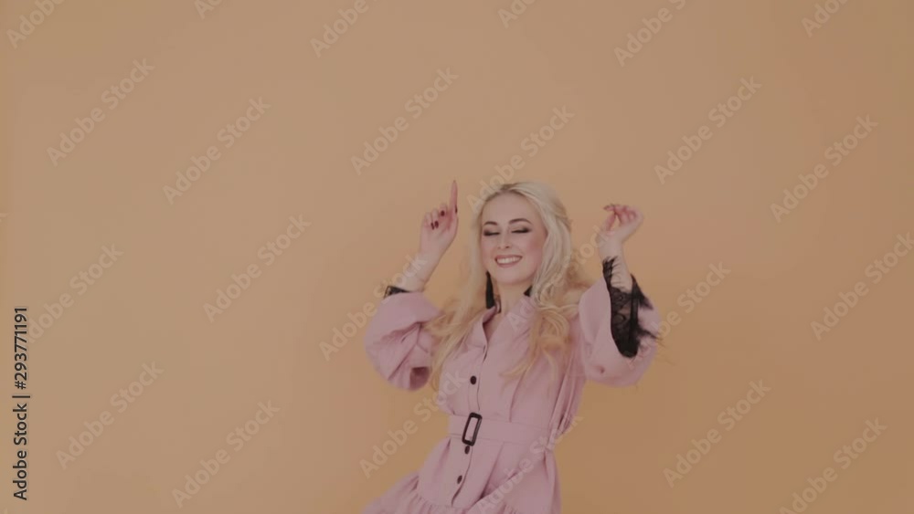 Happy young girl on a yellow background having fun.