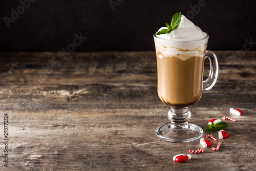 Peppermint coffee mocha for Christmas on wooden table and black background.  Copy space photo