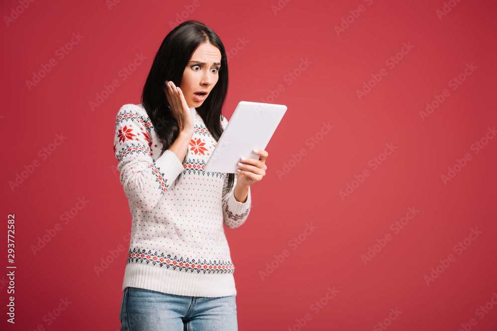 attractive shocked woman using digital tablet isolated on red attractive shocked woman using digital tablet isolated on red